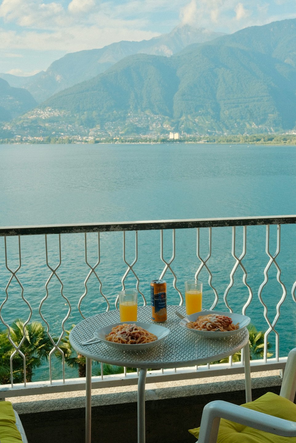 Tavolo da balcone all'aperto con pasta affacciato su lago e montagne.